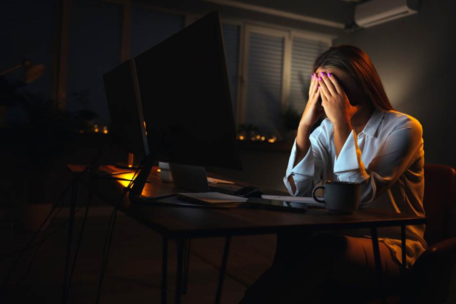 Woman annoyed at laptop late at night - Overtime Violations